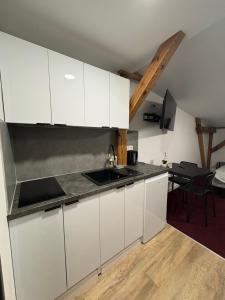 a kitchen with white cabinets and a table at Apartamenty Stary Młyn in Wronki