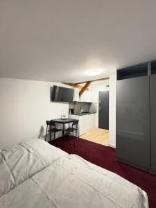 a bedroom with a bed and a table and a kitchen at Apartamenty Stary Młyn in Wronki