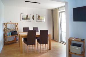a dining room table with black chairs and a tv at Ferienhaus Flora in Pirna