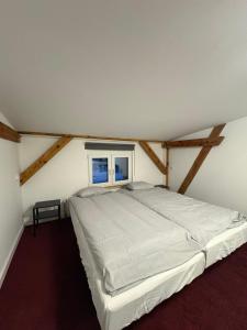 a bedroom with a large bed in a attic at Apartamenty Stary Młyn in Wronki +4 photos