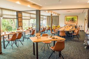 a restaurant with tables and chairs and windows at Hotel-Restaurant Birkenhof in Bad Soden-Salmünster