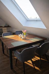 a dining room table with chairs and a skylight at Lysholm Living Luttmersen Ferienwohnung in Neustadt am Rübenberge +4 photos