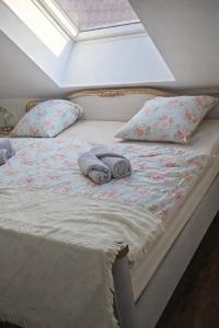 a bed with two pillows and two towels on it at Lysholm Living Luttmersen Ferienwohnung in Neustadt am Rübenberge