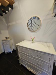 a dresser with a clock on the wall at Lysholm Living Luttmersen Ferienwohnung in Neustadt am Rübenberge