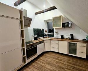 a kitchen with white appliances and wooden floors at Lysholm Living Luttmersen Ferienwohnung in Neustadt am Rübenberge