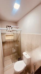 a bathroom with a toilet and a glass shower at Pousada Iracema Charme in Fortaleza
