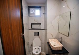 a small bathroom with a toilet and a window at Suncrisp Studio Rooms in Pedda Waltair