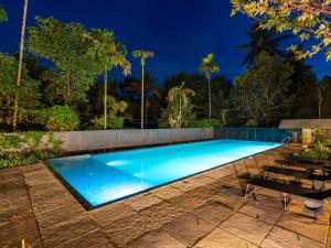 a swimming pool in a resort at night at The Hosteller Wayanad, Vythiri in Vythiri