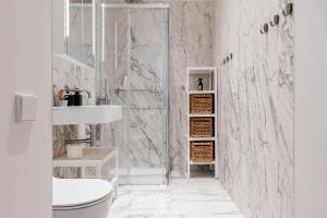 a white bathroom with a shower and a sink at Luxury Central Riga Studio, Raina Nams in Riga +35 photos