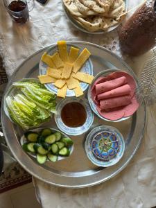 a tray of food with cheese and vegetables on a table at Luxor flats and apartments in Luxor