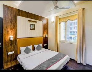 a bedroom with a bed and a window at Hotel MNG The Platinum in Kānpur