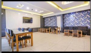 a dining room with tables and chairs and a couch at Hotel MNG The Platinum in Kānpur