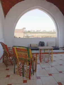 a patio with chairs and a table in a room at Adam and Eve House in Luxor