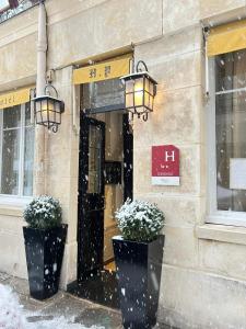 a building with two potted plants in front of a door at Pratic Hotel in Paris