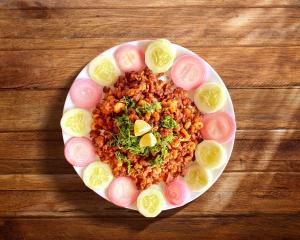 a plate of food with rice and onions on a table at Shlok Villa in Bāmangaon