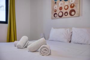 a white bed with towels on top of it at Budget Friendly apartment in Central Swieqi - 10 minutes walk to Paceville & the beach in St. Julianʼs
