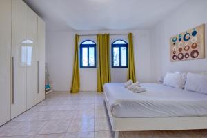 a white room with a bed and two windows at Budget Friendly apartment in Central Swieqi - 10 minutes walk to Paceville & the beach in St. Julianʼs