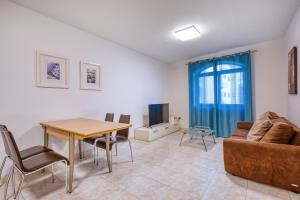 a living room with a table and a couch at Budget Friendly apartment in Central Swieqi - 10 minutes walk to Paceville & the beach in St. Julianʼs +15 photos