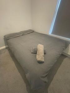 a bed with a towel on it in a room at Modern 3-Bed House in Ramsgate Close to Seafront in Ramsgate