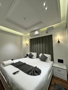 a bedroom with a large bed with white sheets at Hotel La Sera in Srinagar +17 photos