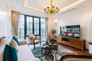 a living room with a couch and a tv at Victoria Suites Westlake Hanoi in Hanoi