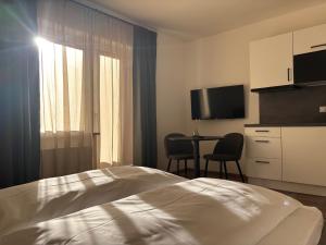 a hotel room with a bed and a table with chairs at Levio Homes Sunny Alpine Apartments with Balconies in Haus im Ennstal