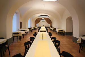 a long table in a room with tables and chairs at Samostan Mekinje in Kamnik