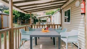 a patio with a table and chairs on a deck at Nice Camps - L Estartit in L'Estartit