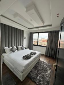 a bedroom with a large white bed with a window at Hotel La Sera in Srinagar