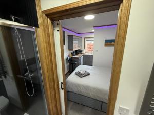 a small bedroom with a bed and a shower at Thurso Accommodation in Castletown