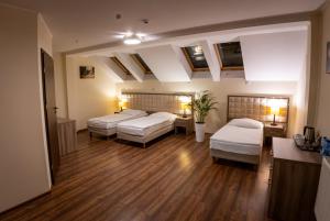 a large room with three beds and a table at Zajazd Pod Borem in Pokój