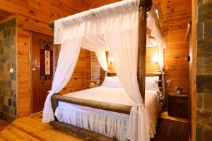 a bedroom with a canopy bed in a cabin at Rosh Pinat Noy in Rosh Pinna +70 photos