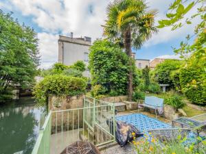 a house with a garden and a river at Beautiful large stylish villa centrally located in Pons in Pons
