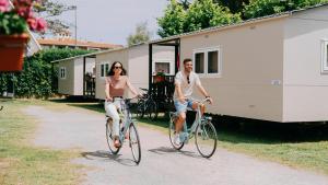 a man and woman riding bikes in front of a trailer at Nice Camps - L Estartit in L'Estartit