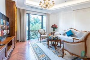 a living room with a couch and a table at Victoria Suites Westlake Hanoi in Hanoi