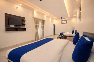 a bedroom with a bed and a tv on the wall at Shree Sita Sadan in Ayodhya +61 photos