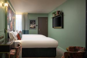 a hotel room with a bed and a tv at The Kensington Hideaway in London