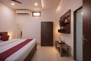 a bedroom with a bed and a desk in a room at Shree Sita Sadan in Ayodhya