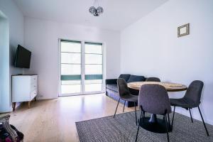 a living room with a table and chairs and a couch at River apartamentai in Druskininkai