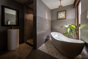 a bathroom with a large tub and a sink at ZenHome by M2 in Hoi An +18 photos