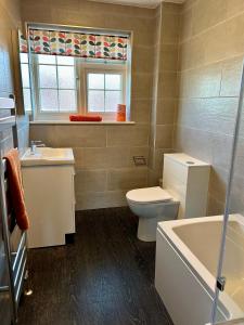 a bathroom with a toilet and a sink and a tub at Bayfields house by the Sea, parking, garden, central location in Portsmouth +12 photos