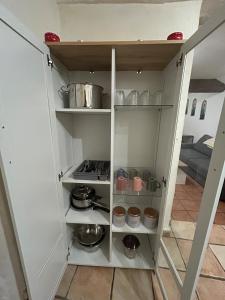 a kitchen with white cabinets with pots and pans at Chez Luna in Sisteron +7 photos