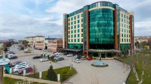 a large building with cars parked in a parking lot at Margi Hotel in Edirne
