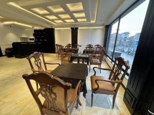 a dining room with tables and chairs and a large window at Hotel La Sera in Srinagar