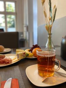 a cup of tea sitting on a table with food at WOHNEN AM SCHLOSSPARK - Bad Salzuflen - nahe Messe, schnelles WLAN, freie Parkplätze, Frühstück verfügbar in Bad Salzuflen
