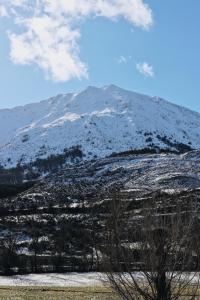 a mountain with snow on it in front of a field at El Mirador del Susarón in Puebla de Lillo