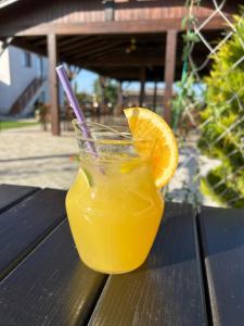 a glass of orange juice sitting on a table at Cazare & Restaurant Dalia in Socodor