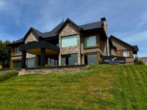 a house on a hill with a sign on it at Ayres de Calafate in El Calafate