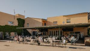 a group of people sitting at tables outside a restaurant at Nice Camps - L Estartit in L'Estartit