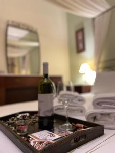 a bottle of wine and a glass on a tray at Evzin Hotel in Kato Loutraki +42 photos